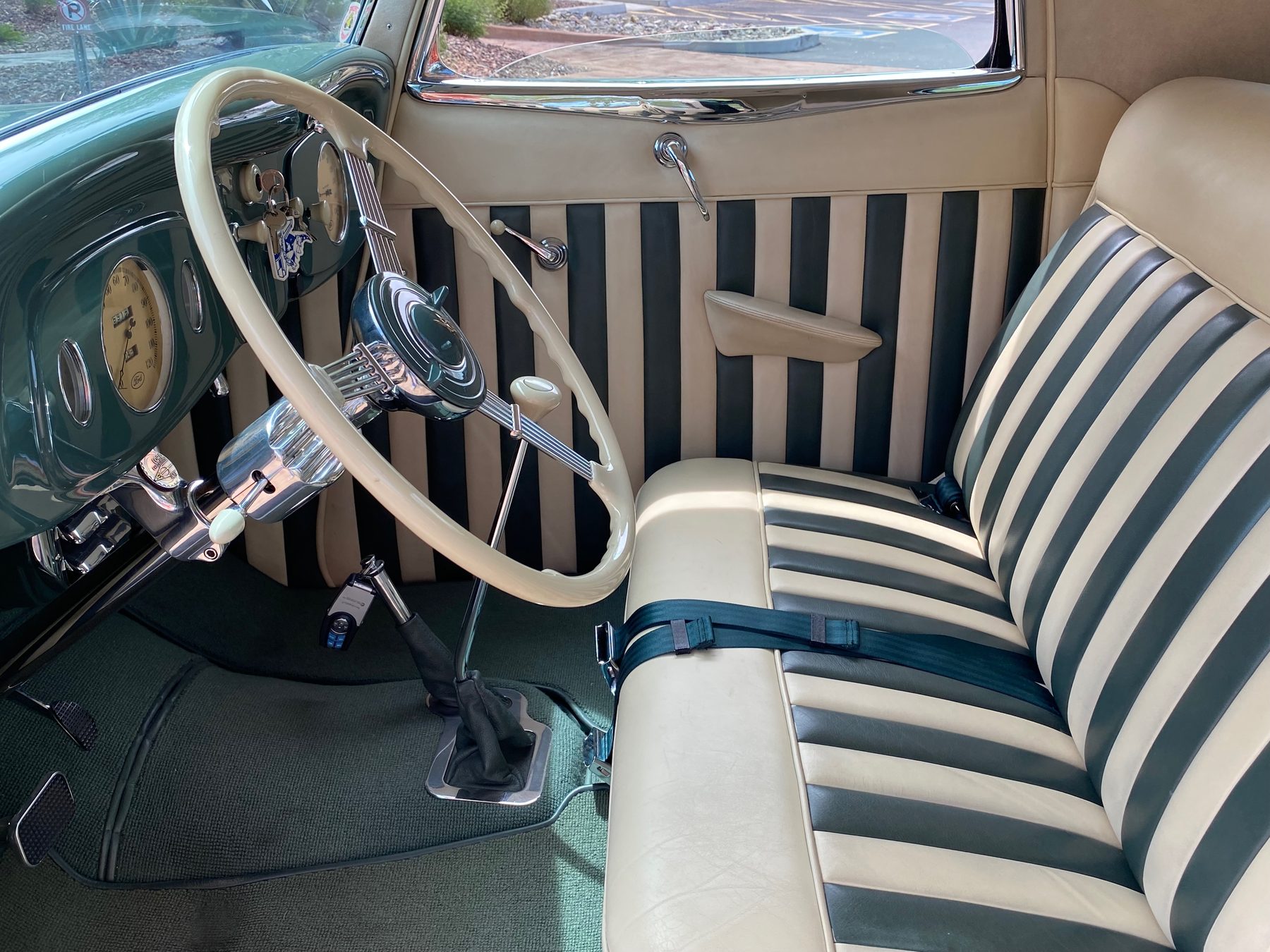 Full interior view with striped bench seat and banjo wheel